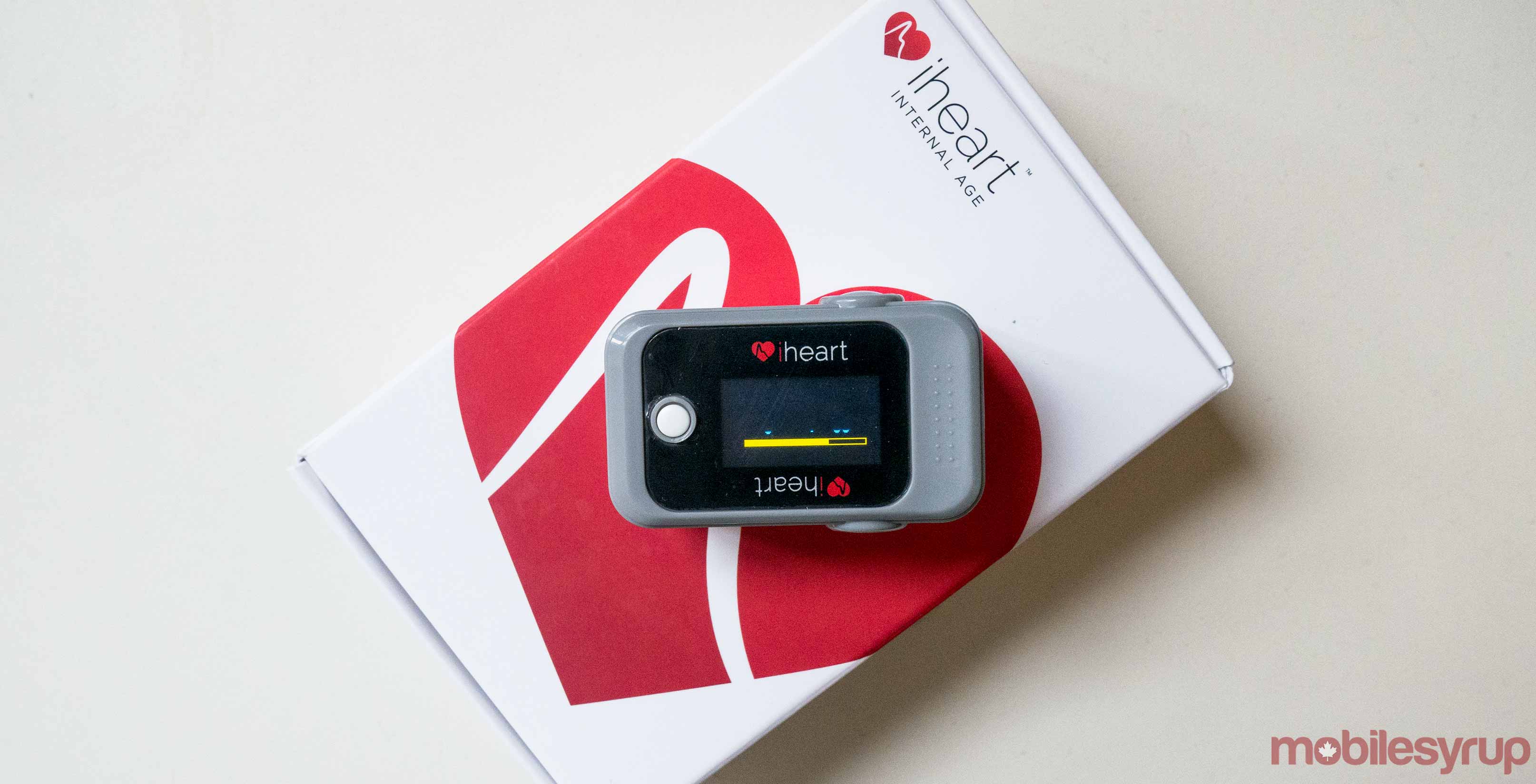 An image showing the iHeart monitor resting on its packaging