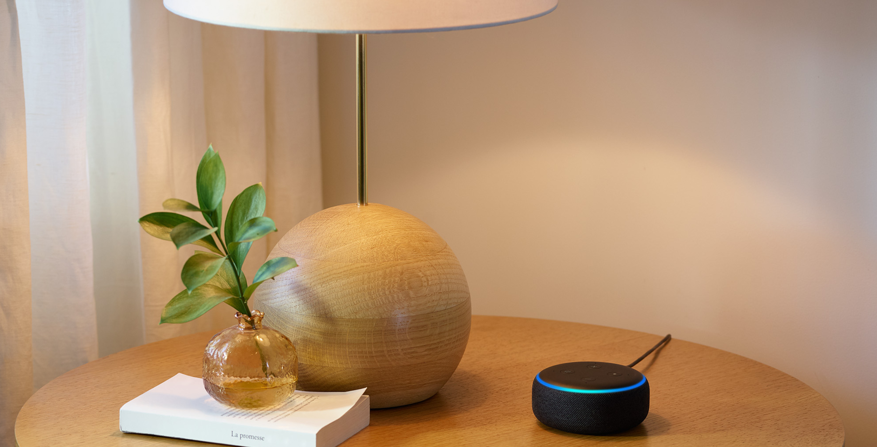 Amazon Echo on a table with a lamp
