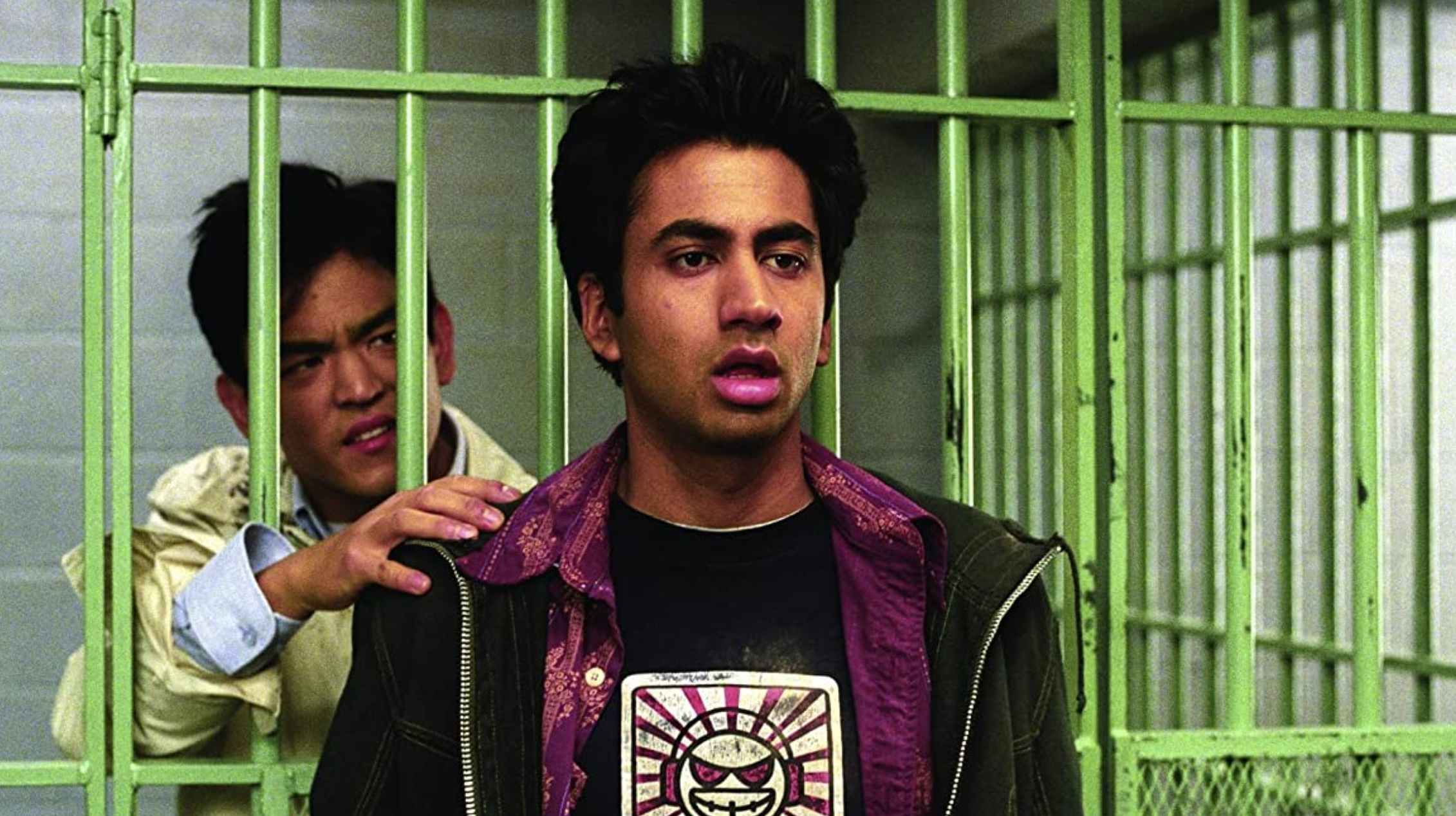 kumar in front of a jail cell and harold is in the cell