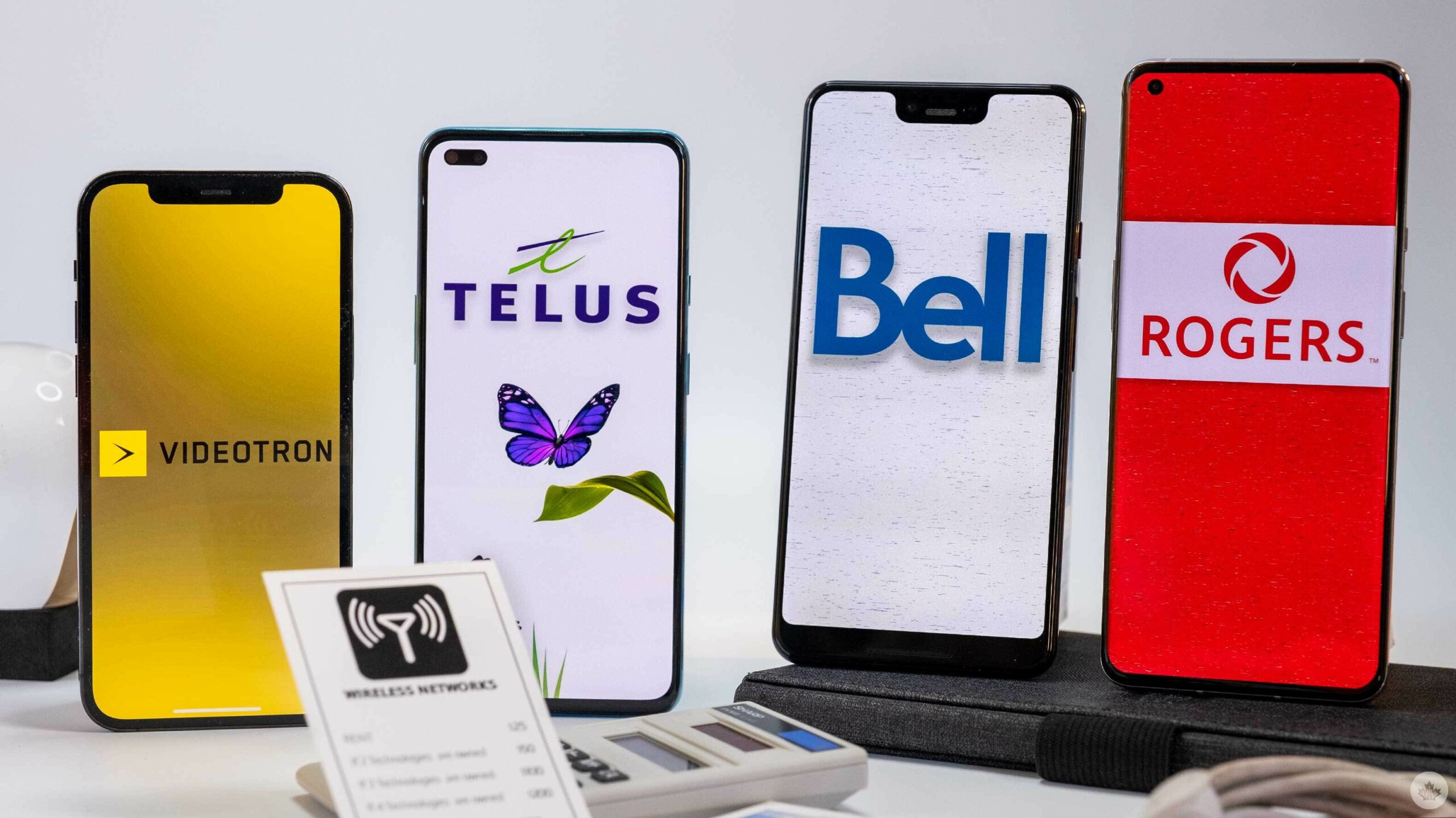 Bell, Rogers, Telus and Vidéotron logos on phones.